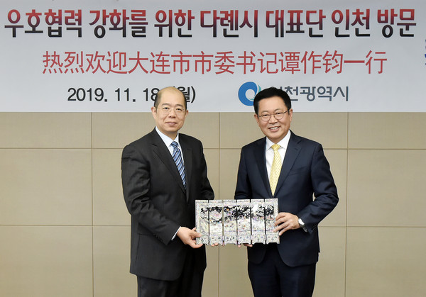 박남춘 인천시장이 18일 송도 G타워에서 우호도시 결연 25주년을 기념해 인천을 방문한 중국 다롄시위원회 탄쭤쥔 서기와 양 도시간 우호관계 발전 방안을 논의한 뒤 선물을 교환하고 있다. (사진제공=인천시청)