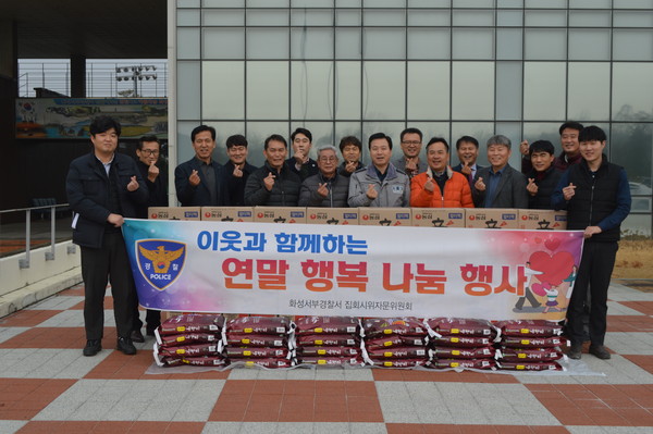 화성서부경찰서는 집회시위자문위원회와 관내 도움의 손길이 필요한 24개 가정에 대해 쌀, 라면 등 생필품 지원을 기념하고 있다.(사진제공=화성서부경찰서)