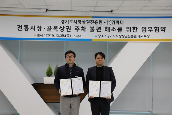 경기도시장상권진흥원(원장 임진, 이하 경상원)과 ㈜위파티(대표이사 이재연)가 전통시장·골목상권의 소비자 주차 불편 해소를 위해 업무협약을 기념하고 있다.(사진제공=경기도시장상권진흥원)