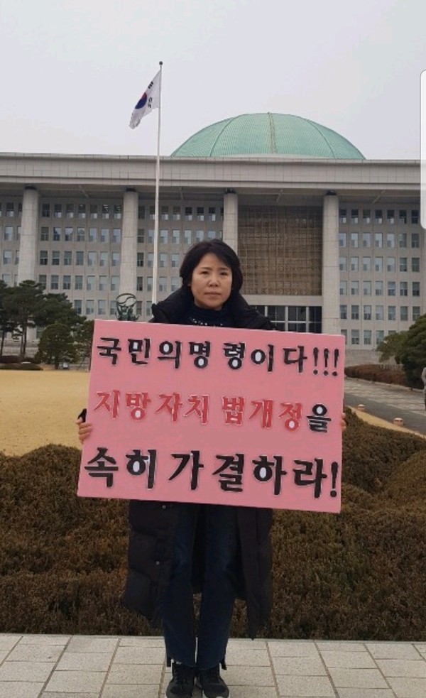 화성시의회 박연숙 의원이 지방자치법 조속개정 촉구 건의안 발의를 국회 앞에서 시위를 진행하고 있다.(사진제공=화성시의회)