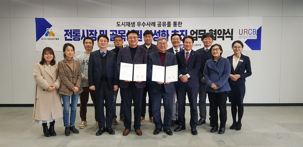 경기도 시장상권진흥원과 부산시 도시재생지원센터가 상생발전 업무협약 체결을 기념하고 있다.(사진제공=경상원)