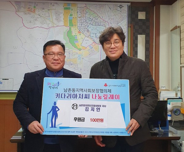 오산시 남촌동행정복지센터와 김명석 남촌동자연보호협의회 회장이 출산한 자녀 이름으로 저소득층을 위한 이웃돕기 성금 전달을 기념하고 있다.(사진제공=오산시청)
