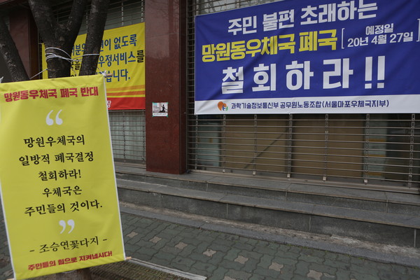 망원우체국 앞엔 우체국 폐국을 반대하는 현수막들이 여럿 걸려있다. (사진=장민호 기자)