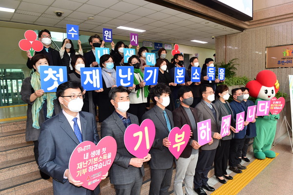 수원시·경기사회복지공동모금회 관계자, 나눔 캠페인 참여자들이 지난 9일 수원시청 본관 1층에서 ‘내 생애 첫 재난 기본 소득을 기부하겠습니다’라는 글이 적힌 카드를 들고 있다. (사진제공=수원시청)