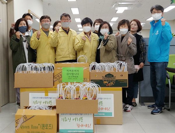 최옥순 수원시사회적기업협의회 상임대표(앞줄 왼쪽 5번째)가 최혜옥 장안구보건소장(앞줄 왼쪽 4번째)에게 격려품을 전달한 후 관계자들과 기념촬영을 하고 있다. (사진제공=수원시청)
