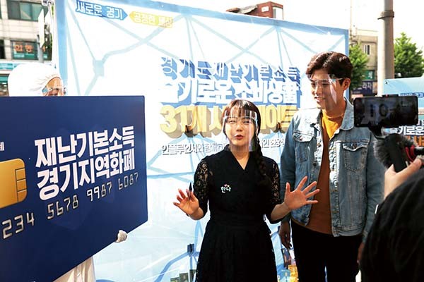 경기도 홍보대사 김일중 아나운서와 유튜버 한나가 지난 7일 부천대학교 인근 상권에서 ‘경기도 재난기본소득 슬기로운 소비생활 31개 시·군 데이트’ 부천시 편을 진행하고 있다. (사진제공=부천시청)