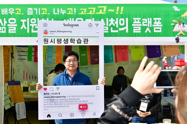 수원시 평생학습축제에 참여한 평생학습관 부스에서 염태영 수원시장이 시민들에게 참여를 독려하는 홍보사진을 찍고 있다. (사진제공=수원시청)