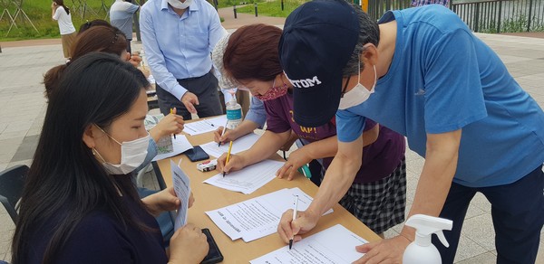 하남 미사지구 행정협의회와 미사1동 주민자치회 준비단이 지난 27일 미사호수공원에서 망월천 수질개선을 위한 시민 설문조사 및 서명운동을 하고 있다.