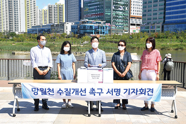 하남시의회 정병용·오지훈 의원을 비롯한 미사1동·미사2동·풍산동 주민자치위원 및 유관단체로 구성된 행정협의회는 지난 8일 호수공원에서 미사지역 최대 현안인 ‘미사호수공원 수질개선 촉구 서명운동 결과’를 발표하는 기자회견을 가졌다. (사진제공=하남시의회)