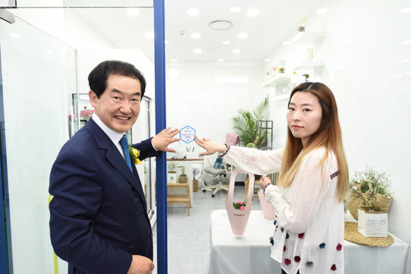 안병용 의정부시장(왼쪽)이 의정부사랑카드 가맹점 스티커 붙이고 있다. (사진제공=의정부시청)