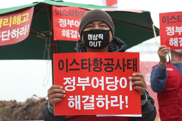 (서울=연합뉴스) 윤동진 기자 = 21일 오전 서울 국회 앞에서 열린 이스타항공 정리해고사태 정부여당 해결 촉구 범시민사회 성명 발표 기자회견에서 민주노총 공공운수노조 등을 비롯한 참가자들이 관련 내용이 적힌 피켓을 들고 있다. 2020.10.21