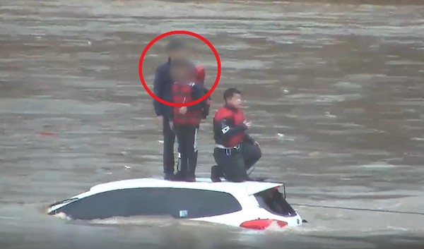 19일 오전 8시 15분께 구리시 사노동 왕숙천에서 길을 건너던 승용차가 갑자기 늘어난 하천 물에 고립됐다가 구조됐다. 원안은 구조를 기다리고 있는 아버지와 아들. (사진제공=구리소방서)