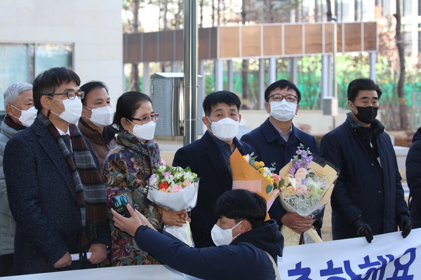 17일 오후 경기도 수원시 영통구 수원지방법원에서 이춘재 연쇄살인 8차 사건의 범인으로 몰려 20년간 옥살이를 했다가 재심에서 무죄를 선고받은 윤성여(맨 우측)씨가 무죄 선고 직후 법원 앞에서 꽃다발을 받고 지인들과 기념촬영을 하고 있다. (사진=최정은 기자)