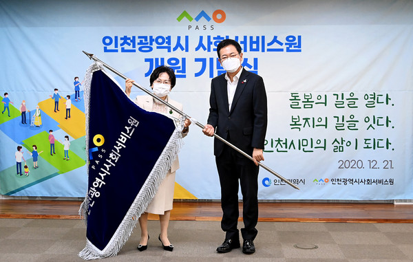 21일 박남춘 인천시장이  시청 접견실에서 열린 ‘인천시 사회서비스원 개원 기념식’에서 유해숙 원장에게 기를 수여한 뒤 기념촬영을 하고 있다. (사진제공=인천시청)