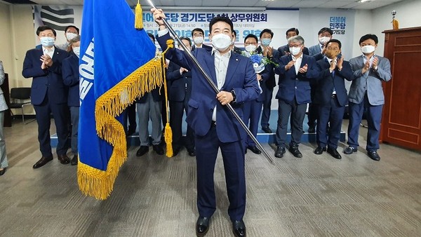 더불어민주당 경기도당은 ‘2021년 사자성어’로 ‘동심단금(同心斷金)’을 선정, ‘모두가 마음을 합해 과거의 잘못된 관행을 과감하게 단절하는 해를 만들어가자’고 호소했다. /사진은 박정 도당위원장이 도당기를 흔들어 보이며 더욱 강한 약진을 다짐하는 모습. (사진=중앙신문DB)