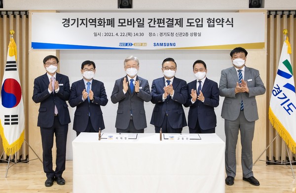 22일 오후 도청 신관 상황실에서 이재명 도지사, 고동진 삼성전자 대표이사 사장, 주은기 삼성전자상생협력센터장, 최윤호 삼성전자 경영지원실장, 김기덕 AI산업전략관, 류광열 경제실장이 참석한 가운데 경기지역화폐 모바일 간편결제 도입 협약식에서 기념촬영을 하고 있다.  (사진제공=경기도청)