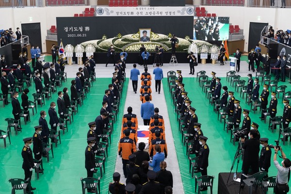 21일 오전 광주시 오포읍 광주시민체육관에서 경기도청장(葬)으로 마련된 고(故) 김동식 소방령 영결식장에서 이재명 장의위원회 위원장(경기도지사)을 비롯한 참석자가 입장하는 운구행렬을 향해 조의를 표하고 있다. (사진제공=경기도청)