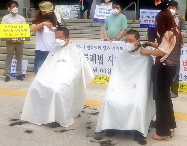 인천 서구 루원시티 주민들을 비롯한 인천지역 주민 단체들이 23일 인천시청 본관 앞에서 루원시티 학교용지 원안 복원 등을 요구하는 기자회견을 연 뒤 삭발식을 진행하고 있다. (사진=김덕현 기자)