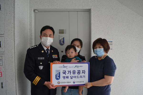 임성순 인천 연수경찰서장(사진 왼쪽)이 고 (故) 김진국 경감의 가족을 찾아 국가유공자 명패를 단 뒤 기념 촬영을 하고 있다. (사진 제공=인천 연수경찰서)