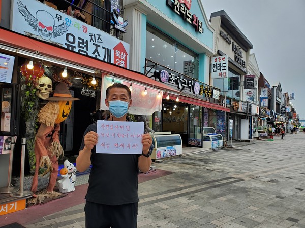 장관훈 월미도번영회장이 지난 11일 오후 인천 중구 월미도의 자신의 가게 앞에서 자영업자의 실질적인 지원 대책 마련을 요구하는 릴레이 캠페인을 벌이고 있다. (사진 제공=월미도번영회)