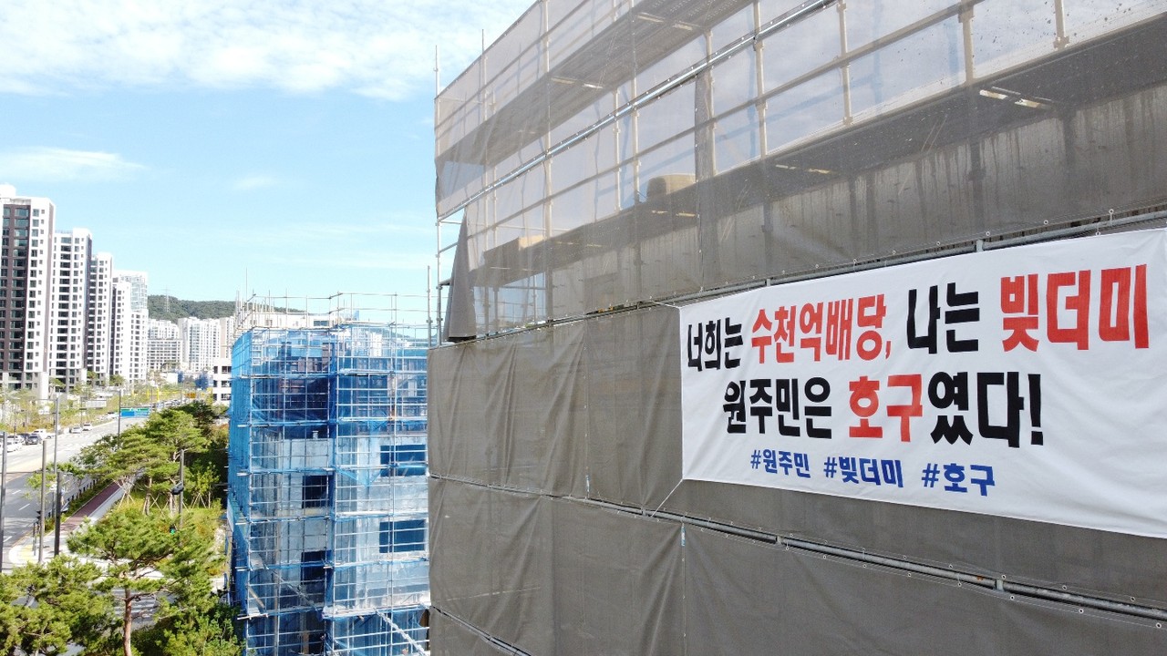 25일 오후 성남 분당 대장지구에 신축되고 있는 한 상가건물에 외벽에 '너희는 수천억배당, 나는 빛더미 원주민은 호구였다'라고 새겨진 현수막이 게시돼 있다. (사진=장은기 기자)