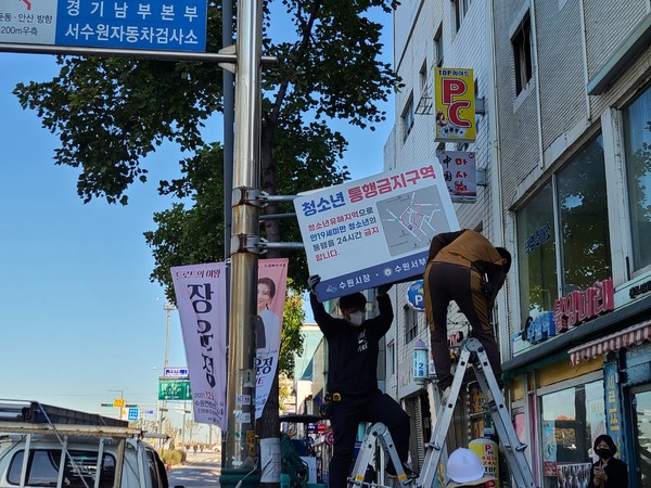 수원시가 28일 오전 ‘청소년통행금지구역’ 안내판을 철거하고 있다. (사진제공=수원시청)