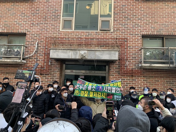 12일 오전 조두순이 거주하는 한 빌라 앞에 조씨를 촬영하기 위해 방문한 유튜버들이 조씨 집 현관에 카메라를 들고 경찰과 대치하고 있다. (사진=나문성 기자)