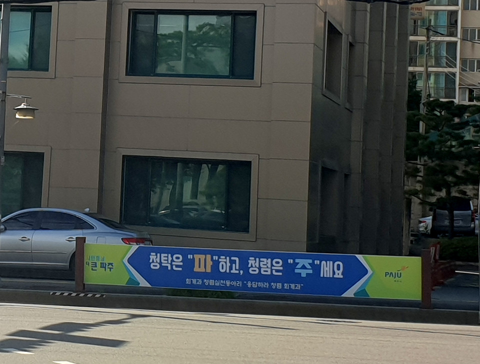파주시청 본관 건너편 감사 담당관실이 들어 있는 별관 앞 횡단보도에 내걸린 "청탁은 '파'하고, '청렴'은 주세요"란 현수막이 행인들의 눈길을 끌고 있다. (사진=박남주 기자)