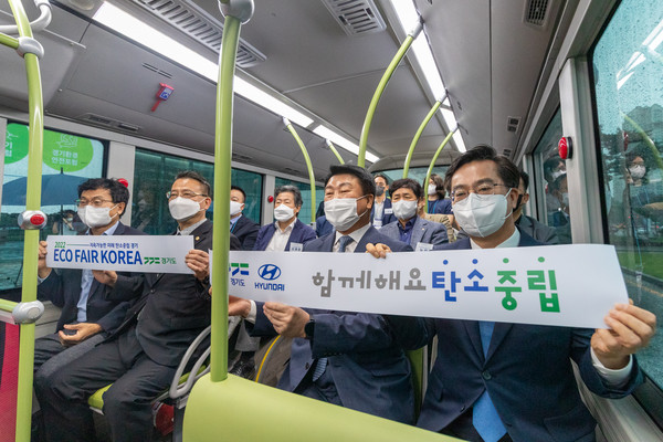 5일 오전 김동연 도지사가 함께 수소버스를 탑승한 기업인들과 탄소중립 BI를 들고 기념촬영을 하고 있다.  (사진제공=경기도청)