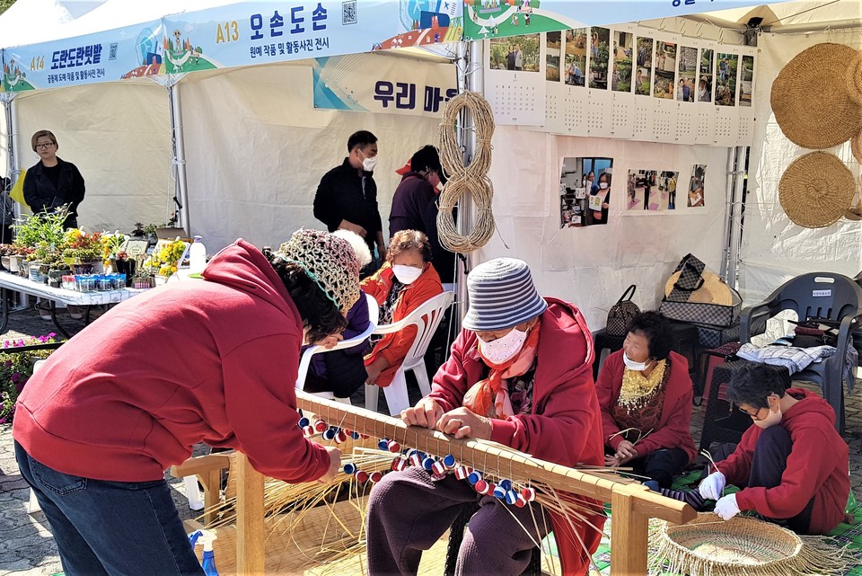 15일 낮 12시께 이천시 설봉공원 토야광장 일대에서 열린 ‘이천시 마을공동체 박람회’에서 한 어르신이 ‘짚공예’ 시범을 보이고 있다. (사진=송석원 기자)