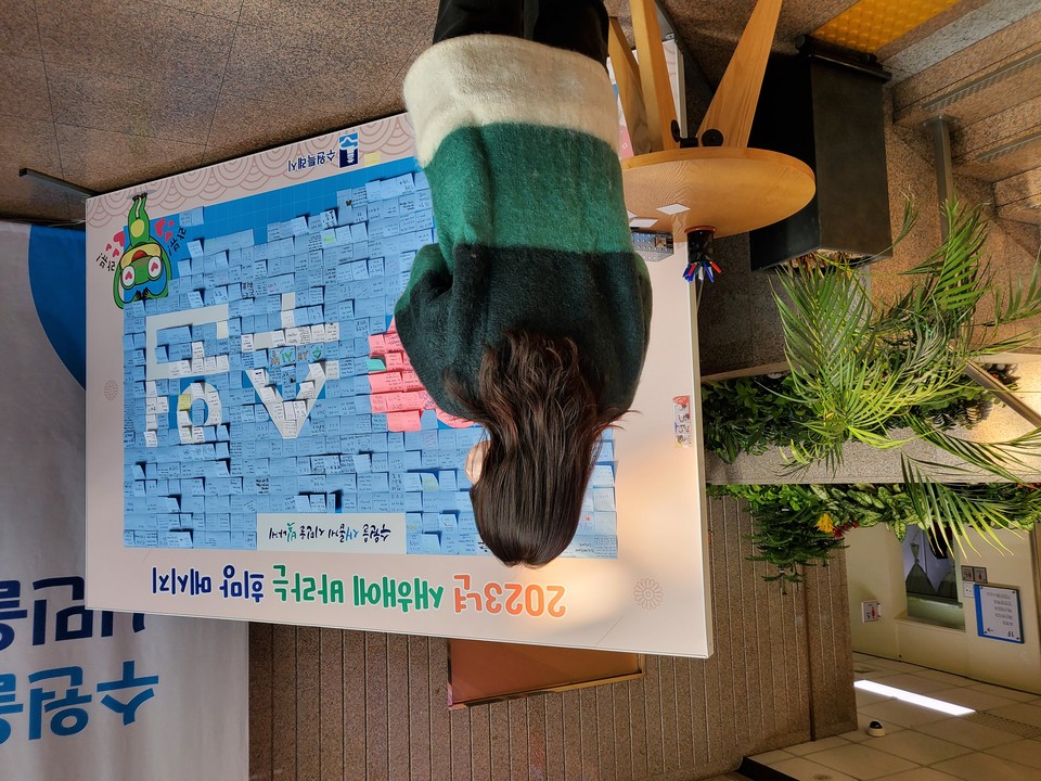 29일 오후 1시께 수원시청 로비에 마련된 ‘2023년 기묘년 새해에 바라는 희망메시지’ 앞에서 한 시민이 메모지에 적을 자신의 소원을 생각하고 있다. (사진=권영복 기자)