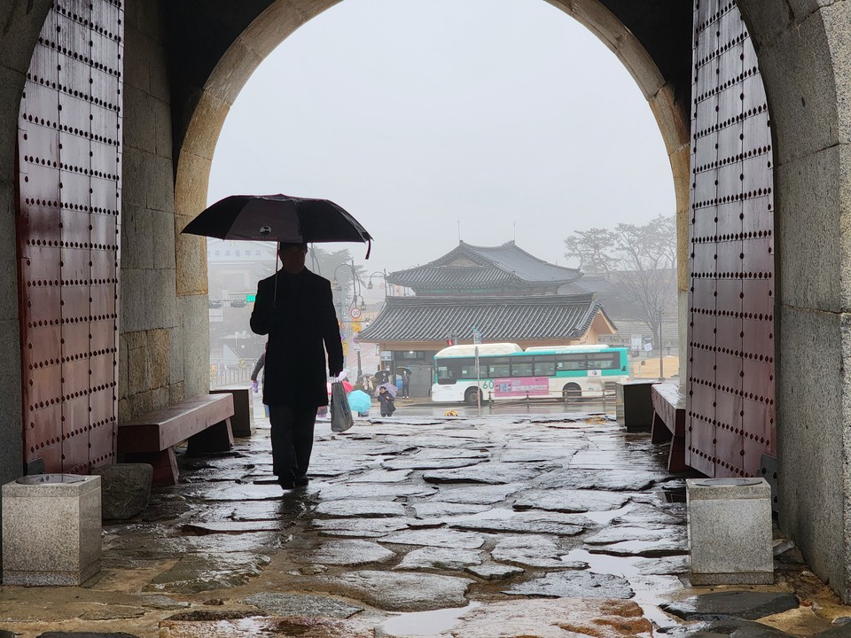​​​​​​​14일 오전 10시3분께 우산을 쓴 노신사가 이슬비 내리는 수원화성 창룡문을 지나고 있다. (사진=권영복 기자)