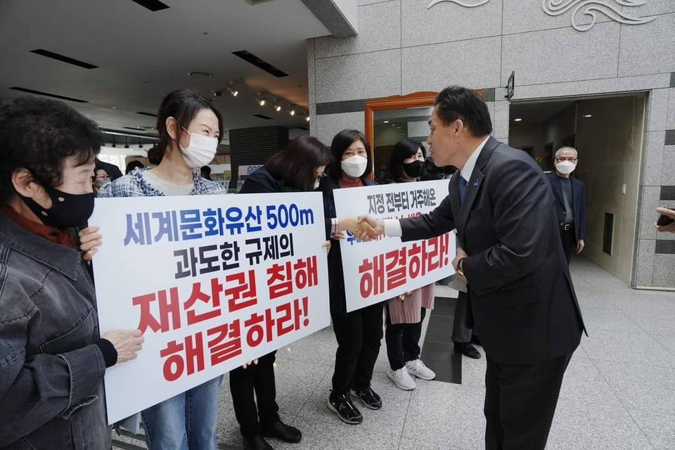 이재준 시장이 수원화성박물관에서 열린 ‘세계유산 수원화성의 가치증진을 위한 역사문화환경 보존지역 개선 정책토론회’장 입구에서 ‘세계문화유산 500m 과도한 규제의 재산권 침해 해결하라’는 피켓을 든 시민들과 인사를 나누고 있다. (사진=이재준 수원시장 페이스북)