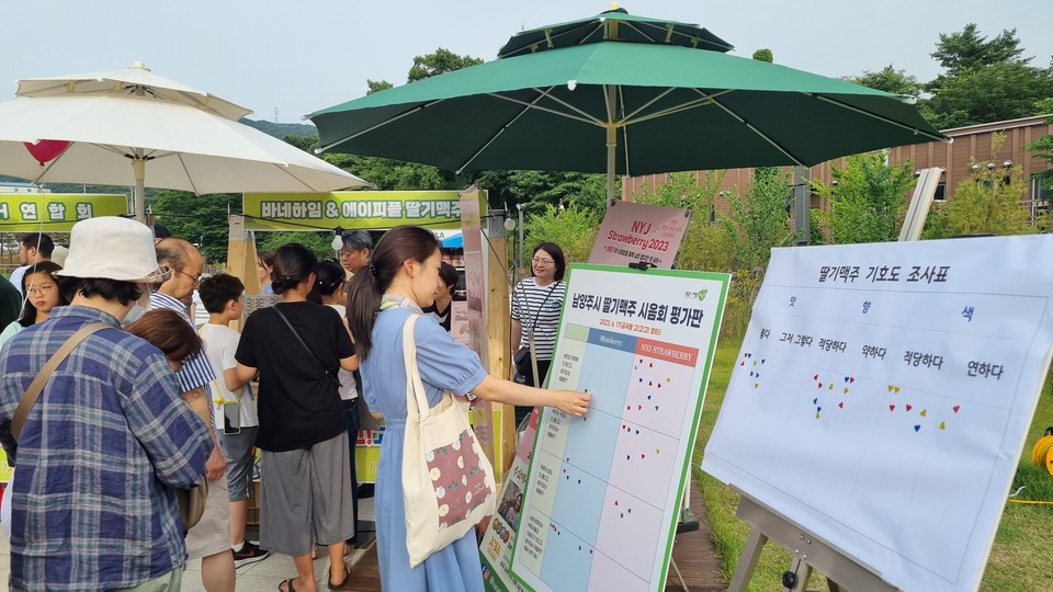경기도농업기술원이 개발한 기술을 사용한 딸기맥주가 시제품으로 만들어져 일반에 공개됐다. 맥주시음회에 참가한 시민들이 맛을 평가하고 있다. (사진제공=경기도농업기술원)