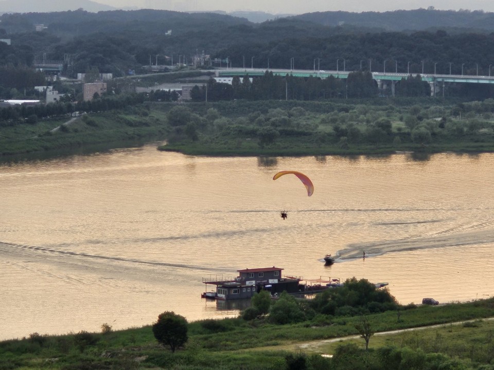 26일 오후 6시10분께 한 동력패러글라이더가 여주시 남한강변 상공을 비행하고 있다. (사진=김광섭 기자)