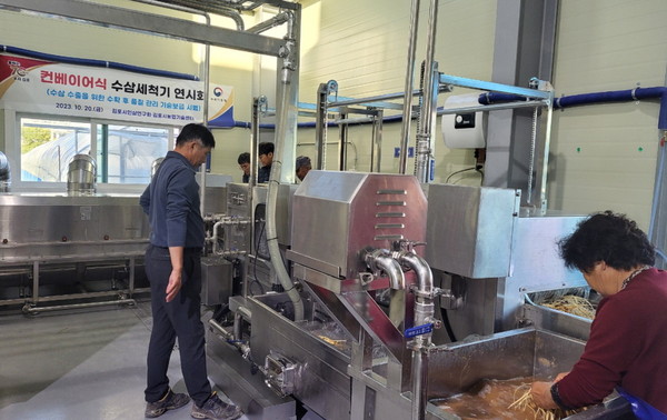 김포인삼연구회 회원들이 컨베이어식 수삼세척기 연시회를 세척을 시연하고 있다.(사진제공=김포시농업기슬센터)