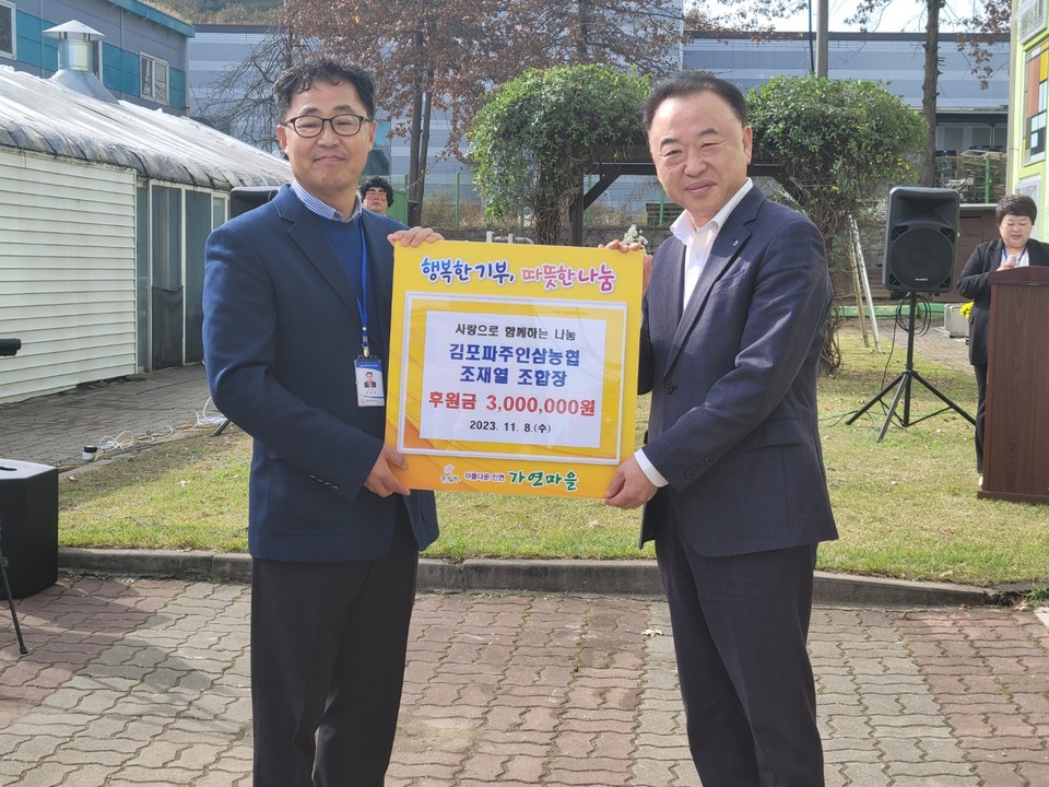 김포파주인삼농협 상임이사가 이덕주 가연마을 원장에게 성금을 전달한 뒤, 기념사진을 촬영하고 있다. (사진제공=김포파주인삼농협)