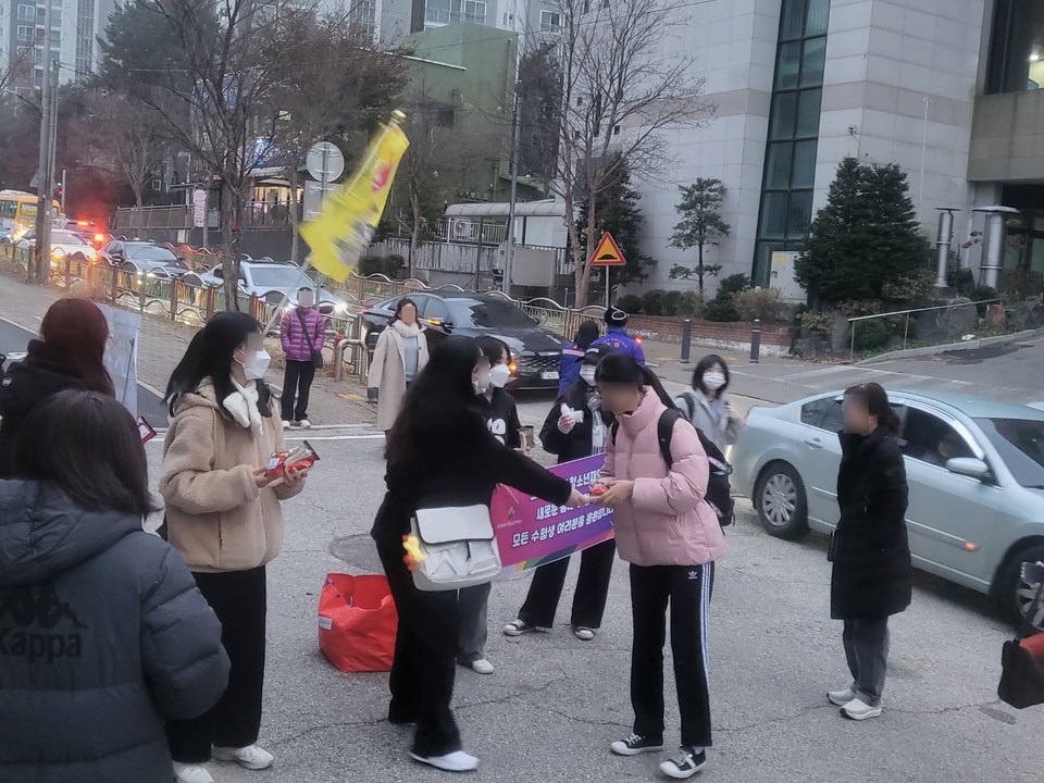 16일 오전 7시께 의정부 금오동 효자고등학교에 마련된 경기도교육청 제32지구 제5시험장에서 일찍 나온 의정부시청소년재단 직원들이 미리 준비한 따뜻한 물과 손난로를 수험생들에게 나눠주며 격려하고 있다. (사진=강상준 기자)