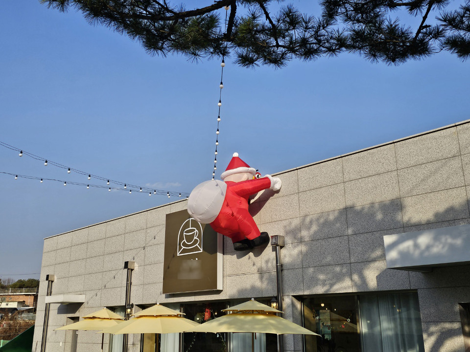 8일 오후 2시50분께 여주시 세종대왕면에 있는 한 카페 입구에 앙증맞은 산타가 선물을 등에 메고 담을 넘고 있다. (사진=김광섭 기자)