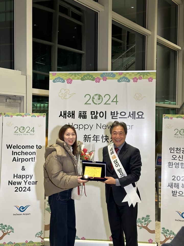 인천국제공항공사가 1일 인천공항 제2여객터미널 입국장에서 대한항공과 함께 ‘2024년 새해 첫 여객 환영행사’를 개최했다. 사진은 이날 대한항공 KE854편(베이징→인천)을 통해 인천공항에 도착한 새해 첫 여객 쫑위에(Zong-yue, 중국 국적)씨에게 황금 기념패, 대한항공 왕복 항공권, 호텔(그랜드하얏트 인천) 숙박권 등의 선물이 증정됐다. (사진제공=인천국제공항공사)