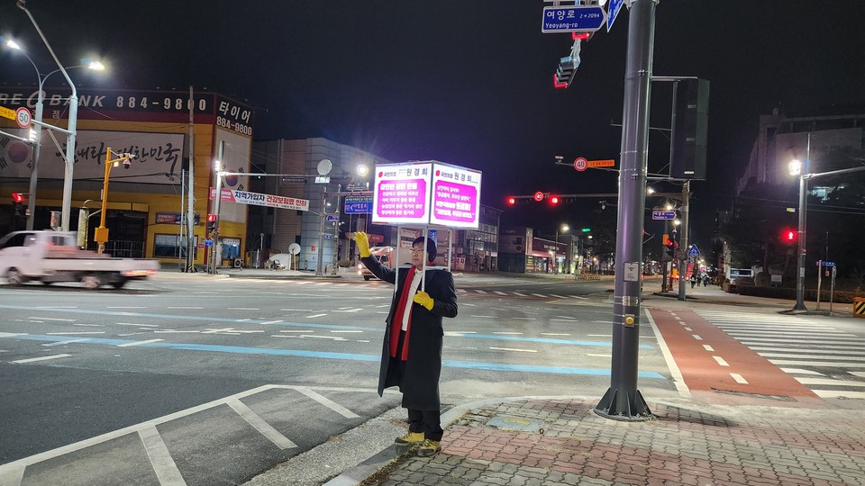 원경희 국민의힘 예비후보가 9일 새벽 자신의 공약이 담긴 이색적인 LED 홍보물을 어깨에 메고 시민들을 향해 아침 인사를 건네고 있다. (사진제공=원경희 예비후보측)
