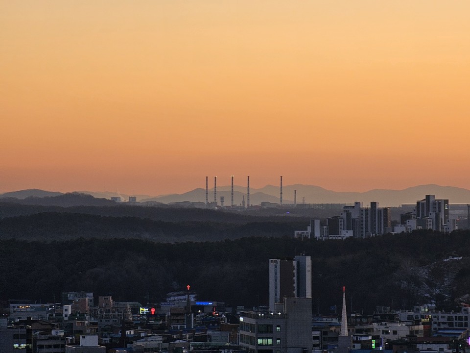 15일 오후 5시43분께 여주 현암동에서 바라본 남서쪽 하늘에 붉게 물든 노을이 KCC 여주공장 굴뚝 뒤로 보이고 있다. (사진=김광섭 기자)