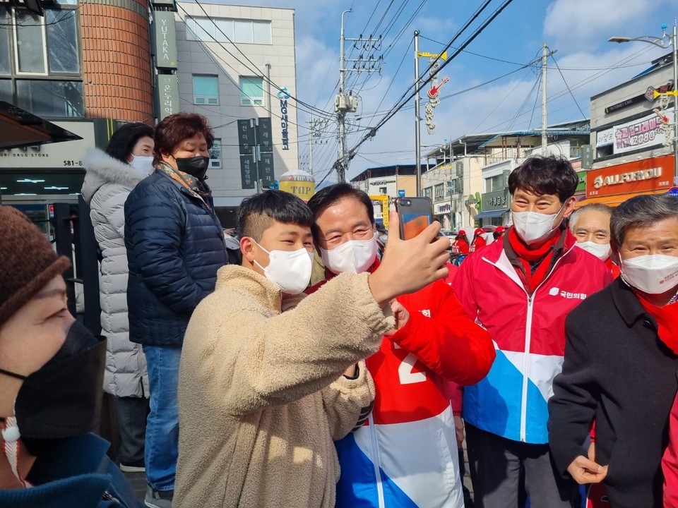15일 오후 가평 유세현장에서 최춘식 국회의원(포천·가평)이 한 청년과 셀카를 찍고 있다. (사진=김성운 기자)