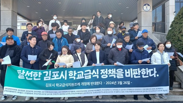 김포민주시민사회단체연대회 회원들이 김포시청 현관 앞에 모여 기자회견을 열고 ‘김포시 학교급식 등 지원에 관한 조례' 재개정을 촉구하고 있다. (사진=권용국 기자)