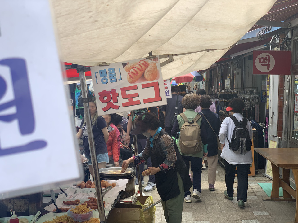 25일 오후 1시 20분께 동두천시 생연2동 큰 시장에 오일장이 서고 있다. 핫도그 가게 주인의 튀김 튀기는 손길이 지나는 사람들의 눈길을 끌고 있다. (사진=오기춘 기자)