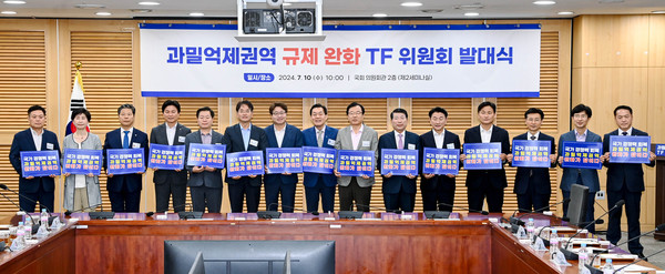과밀억제권역 규제 완화 TF위원회 대표위원장으로 선출된 이재준 수원시장(오른쪽 8번째부터), 염태영 의원, 이동환 고양시장 등이 TF 위원회 발대식 후 ‘국가경쟁력 회복 과밀억제권역 완화가 답이다’라는 문구가 적힌 손팻말을 들고 기념촬영을 하고 있다. (사진제공=수원시청)