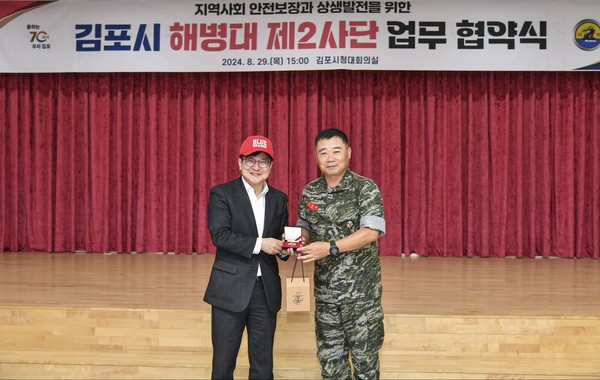 김포시와 해병대 제2사단이 관·군 상생발전을 위한 협약을 체결하면서, 접경지역 군·관 상생발전협력체의 롤모델로 부상하고 있다. 김병수 시장과 정종범 사단장이 업무협약 후, 기념품을 전달하며 포즈를 취하고 있다. (사진제공=김포시청)