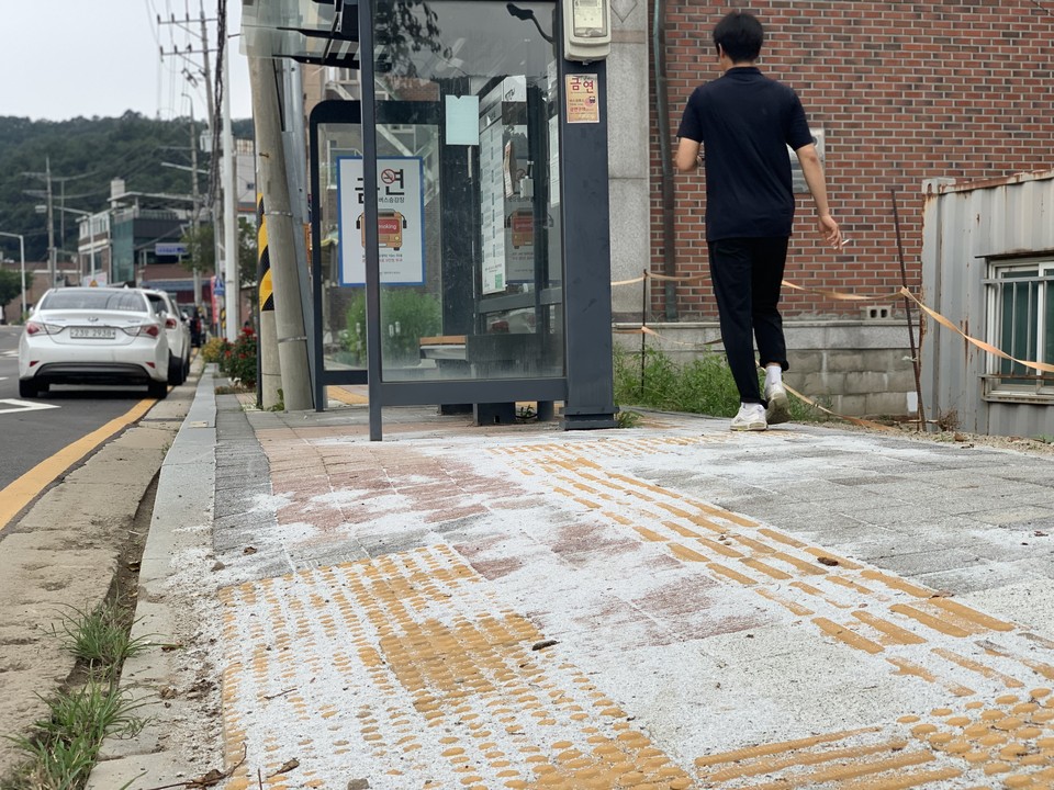 5일 오전 11시40분께 동두천시 광암동의 한 버스정류장 옆 인도 보도블록공사 현장에 규사로 보이는 석분이 뿌려진 채 방치되고 있어 시민들의 분통을 사고 있다. (사진=오기춘 기자)