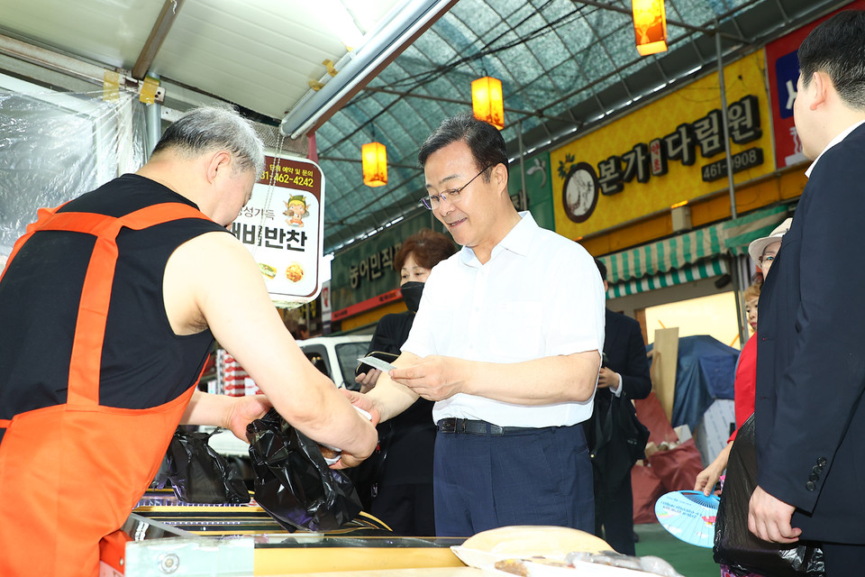 김성제 의왕시장이 13일 전통시장 활성화를 위해 의왕도깨비시장을 직접 찾아 제수용품과 성수품 등을 구매하고 있다. (사진제공=의왕시)