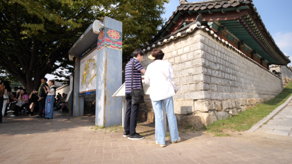 시각장애인 김OO씨(왼쪽)가 문화관광해설사와 함께 수원화성을 관광하고 있다.